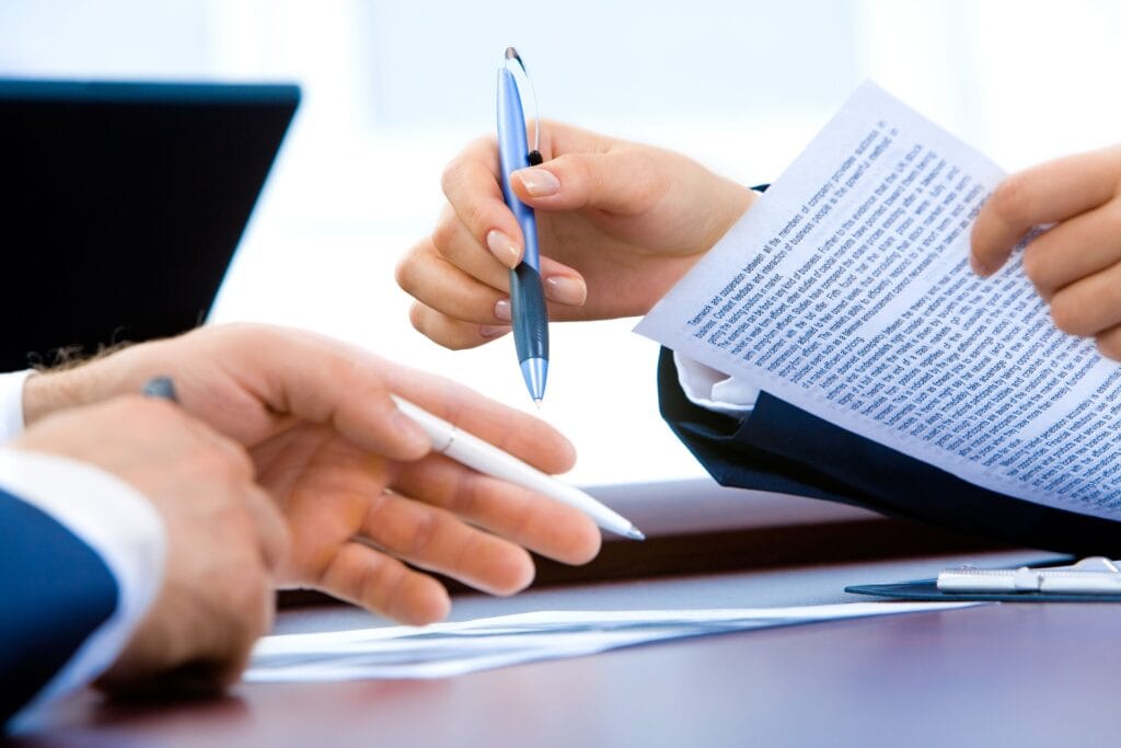 Hands exchanging documents and pens