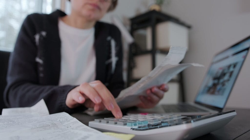 woman doing taxes with a calculator
